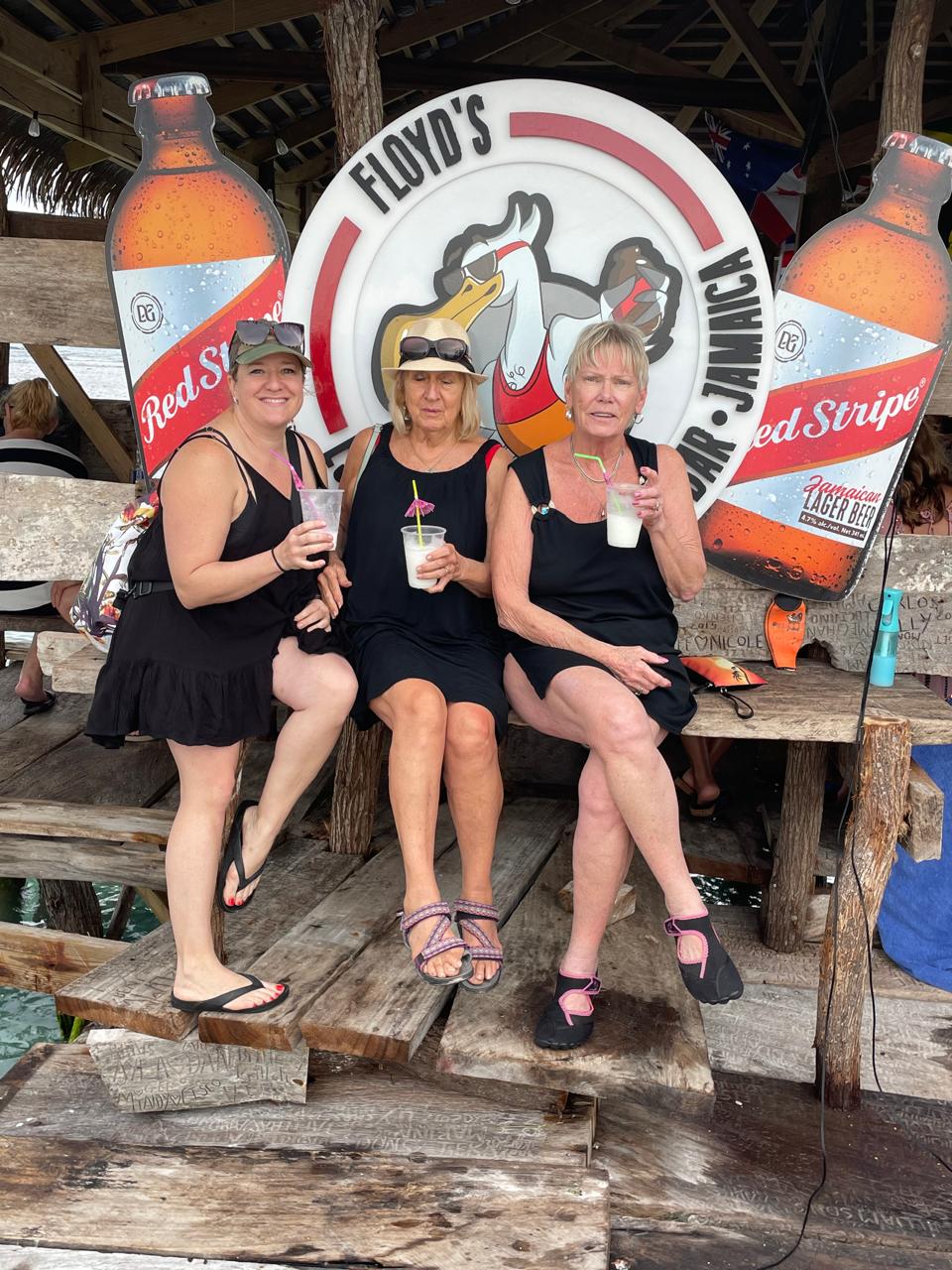 Three friends with cocktails at Floyd's Pelican Bar
